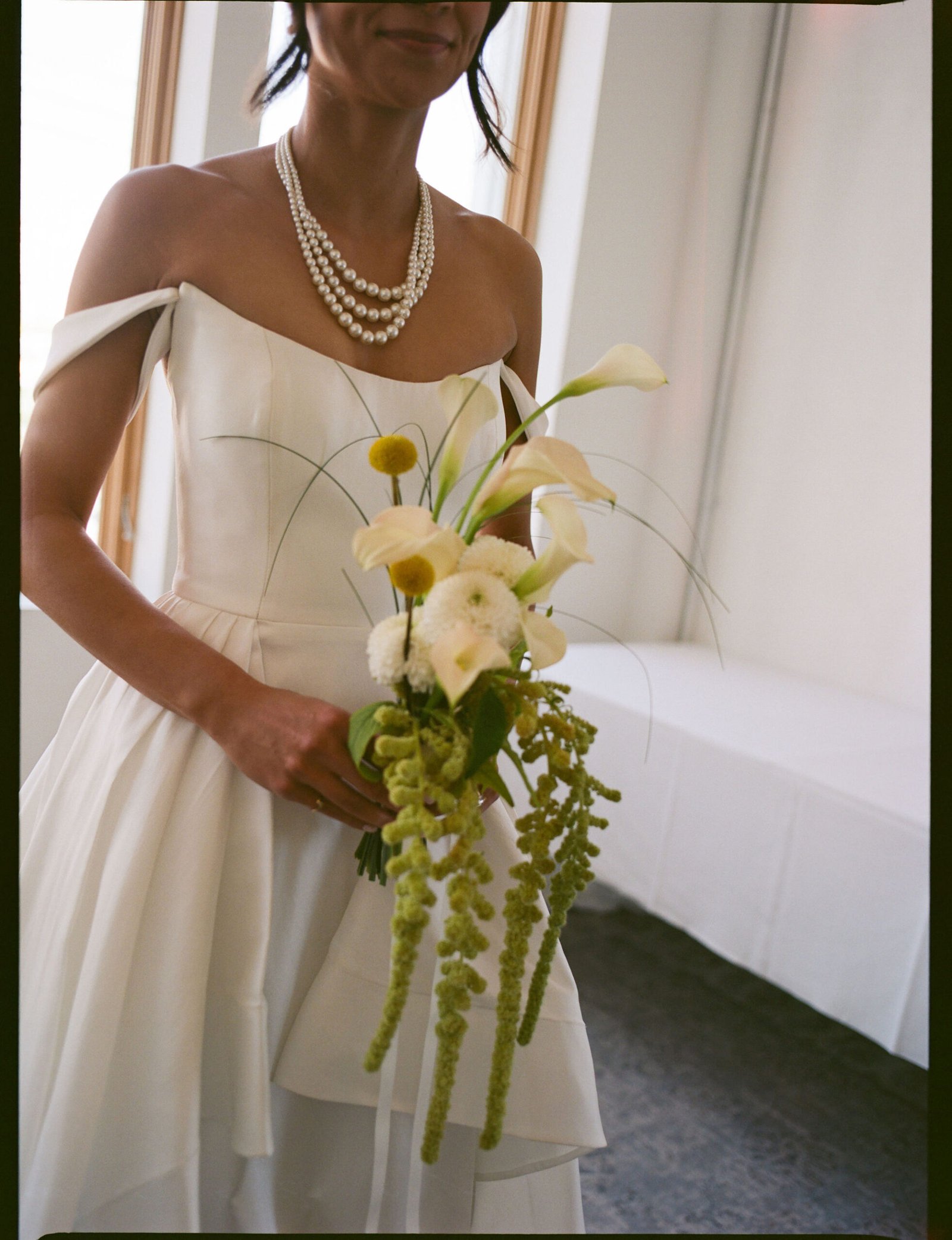 Bride Lauren in a minimalist white wedding dress with flowers.