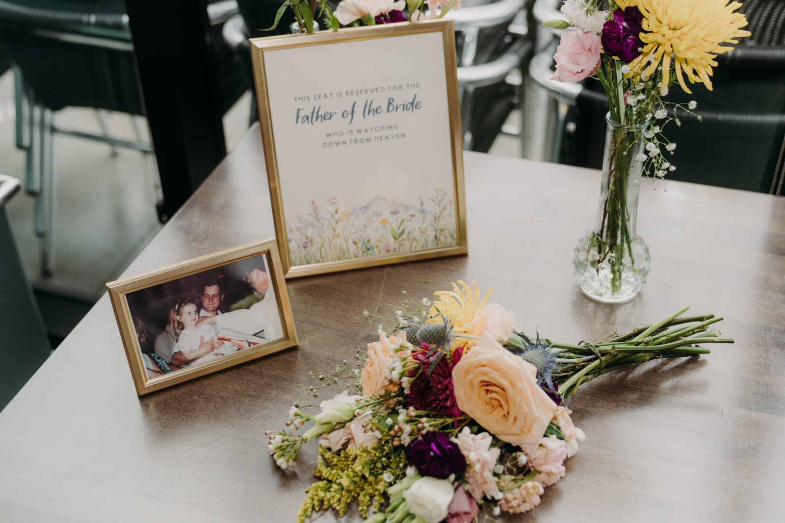 Wedding memorial table for the father of the bride with a framed sign and vintage photograph.
